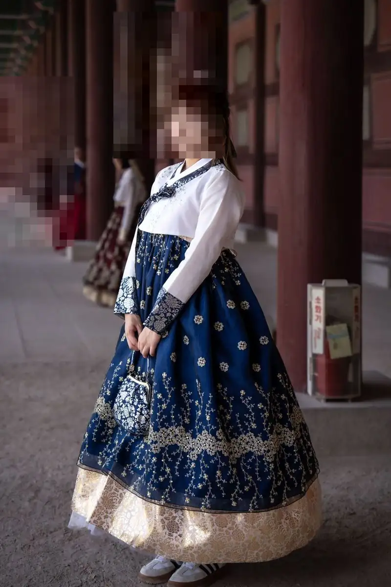 전통 한정식의 품격을 보여주는 남색 꽃무늬 한복 차림의 여성